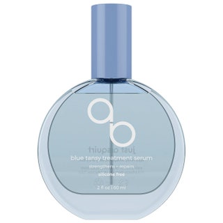 Round bottle of Adwoa Beauty Blue Tansy Treatment Serum on white background