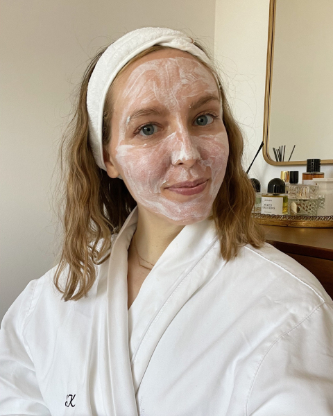 A photo of a woman wearing a white robe and headband with a white face mask on